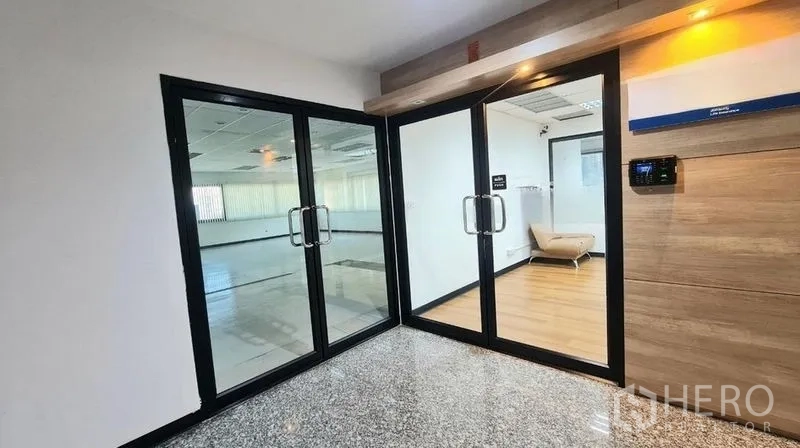 Office Space for rent in Watthana, Bangkok - Secure glass entry with keypad leading to a modern office and small lounge area.