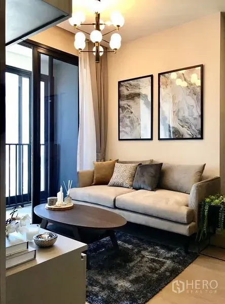 คอนโด ให้เช่าในWatthana, Bangkok - ห้องนั่งเล่นอบอุ่น โซฟา โต๊ะกลาง และทางออกสู่ระเบียง