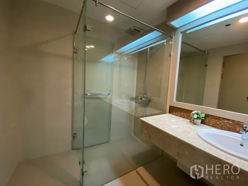 Condominium for rent in Watthana, Bangkok - Modern bathroom with glass-enclosed shower and wide vanity.
