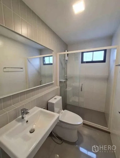 ทาวน์เฮาส์ ให้เช่าในBang Phli, Samut Prakan - ห้องน้ำสมัยใหม่ มีตู้ชาวเวอร์กระจก หน้าต่าง อ่างล้างหน้า และโถสุขภัณฑ์