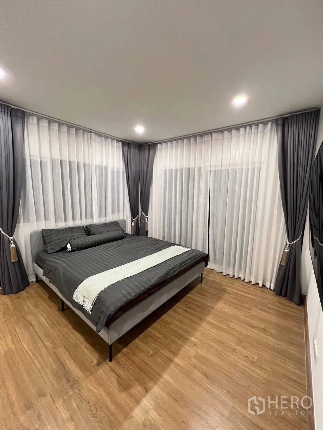 บ้านเดี่ยว for rent in Prawet, Bangkok - ห้องนอนมุมบ้านพร้อมผ้าม่านรอบด้าน ไฟดาวน์ไลต์ และเตียงควีนไซส์.