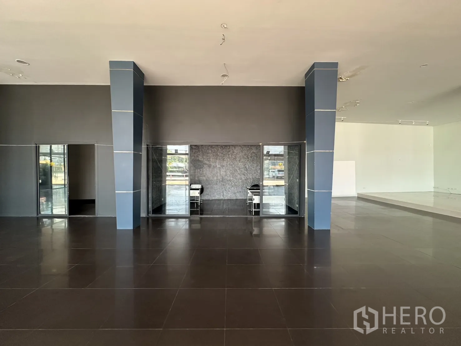 展厅 for rent in Suan Luang, Bangkok - 中央立柱分隔的玻璃办公室与开阔销售区。