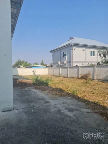 โรงงาน ให้เช่าหรือขายในLam Luk Ka, Pathum Thani - พื้นที่ด้านหลังอาคารโล่ง พร้อมกำแพงรั้วติดบ้านข้างเคียง