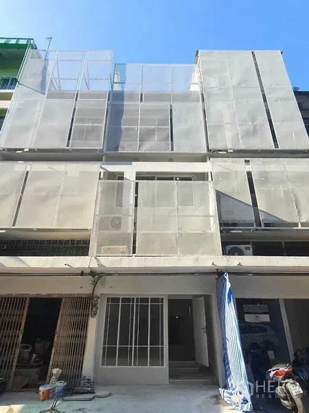 店屋 出租在Phra Khanong, Bangkok - 现代多层店铺外立面，穿孔金属屏风与一层入口。