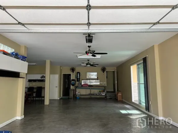 Detached House for rent in Bang Kapi, Bangkok - Large multipurpose room with ceiling fans, sectional garage door and polished floor.