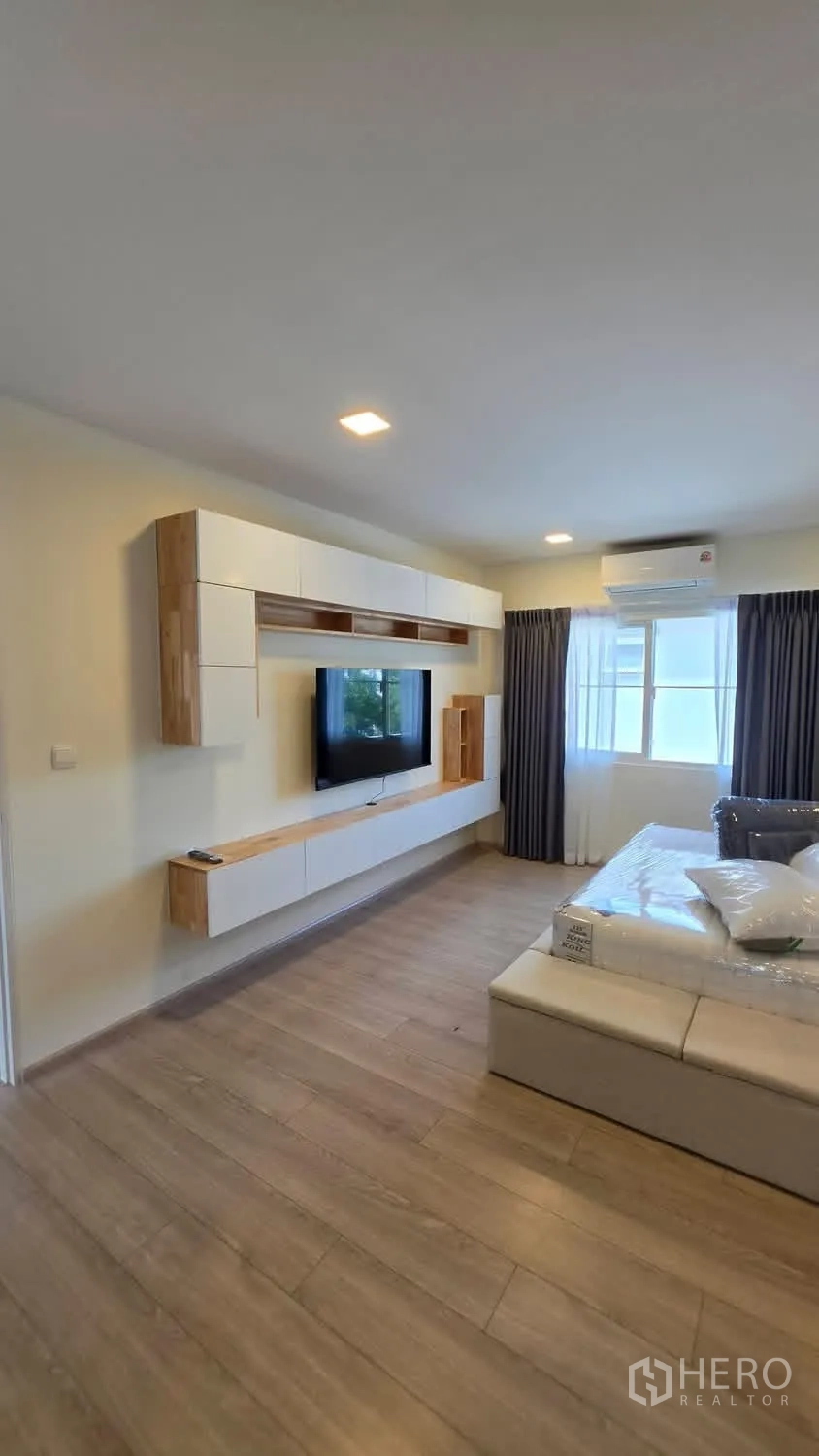 Detached House for rent in Bang Phli, Samut Prakan - Bedroom lounge with wall-mounted TV, floating cabinets, and AC.