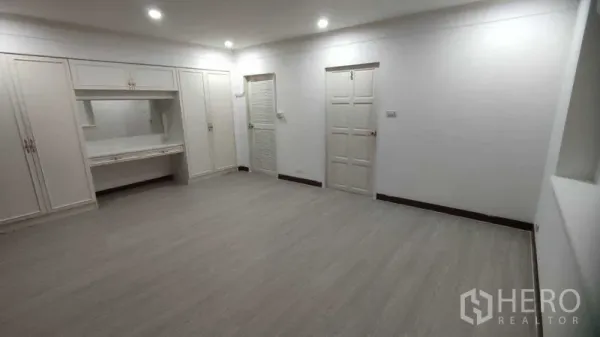 Home Office for rent in Watthana, Bangkok - Spacious white bedroom with built-in wardrobe, vanity and recessed lighting.