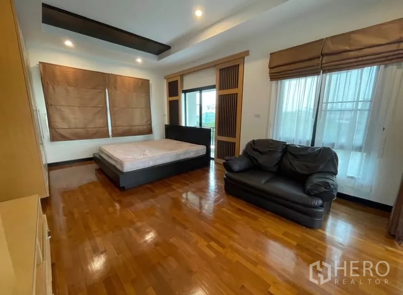 บ้าน ให้เช่าในChatuchak, Bangkok - ห้องนอนหลักกว้างพื้นไม้ โซฟา และประตูออกไประเบียง