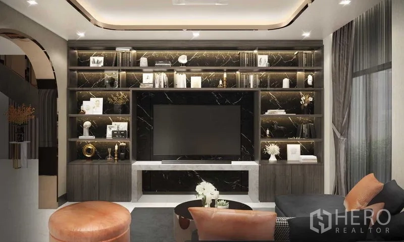Detached House for sale in Prawet, Bangkok - Luxury living room with marble TV wall, built-in shelves and sectional sofa in a detached house in Prawet, Bangkok.