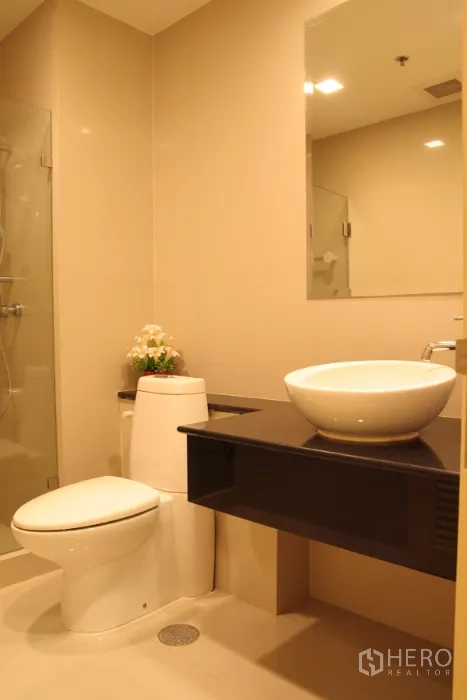 คอนโด ให้เช่าในKhlong Toei, Bangkok - อ่างล้างหน้าแบบวางบนเคาน์เตอร์ กระจก และชั้นวาง ข้างตู้ฝักบัว