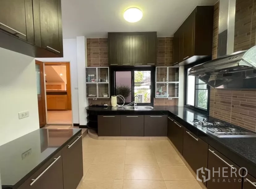 บ้าน ให้เช่าในChatuchak, Bangkok - ครัวบิลท์อินตู้สีเข้ม เตาแก๊ส และท็อปหินแกรนิตสีดำ