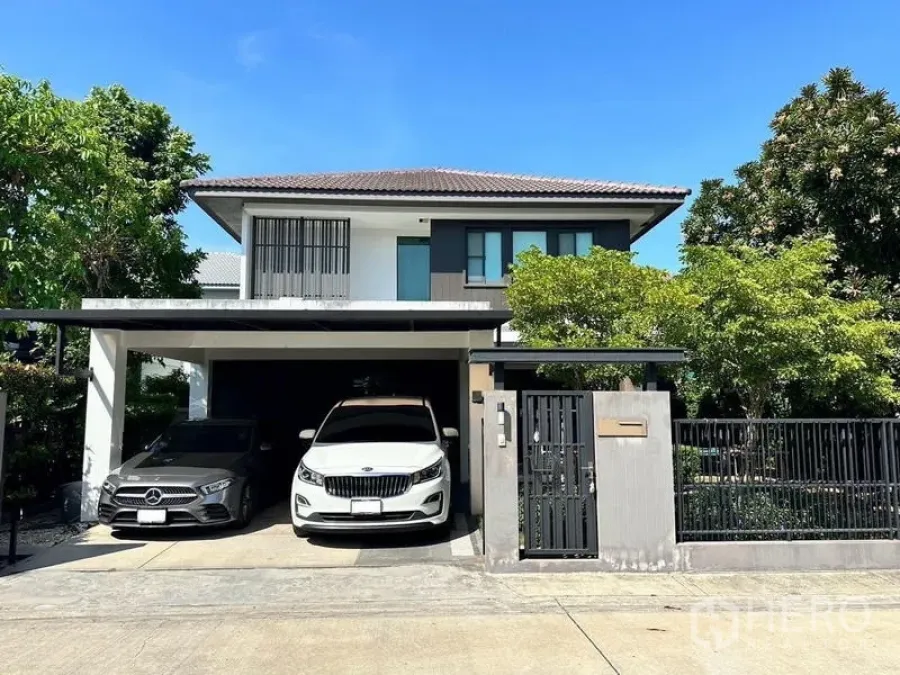Detached House for rent in Bang Phli, Samut Prakan - Front elevation of the contemporary detached house with black metal gate, greenery and double carport.