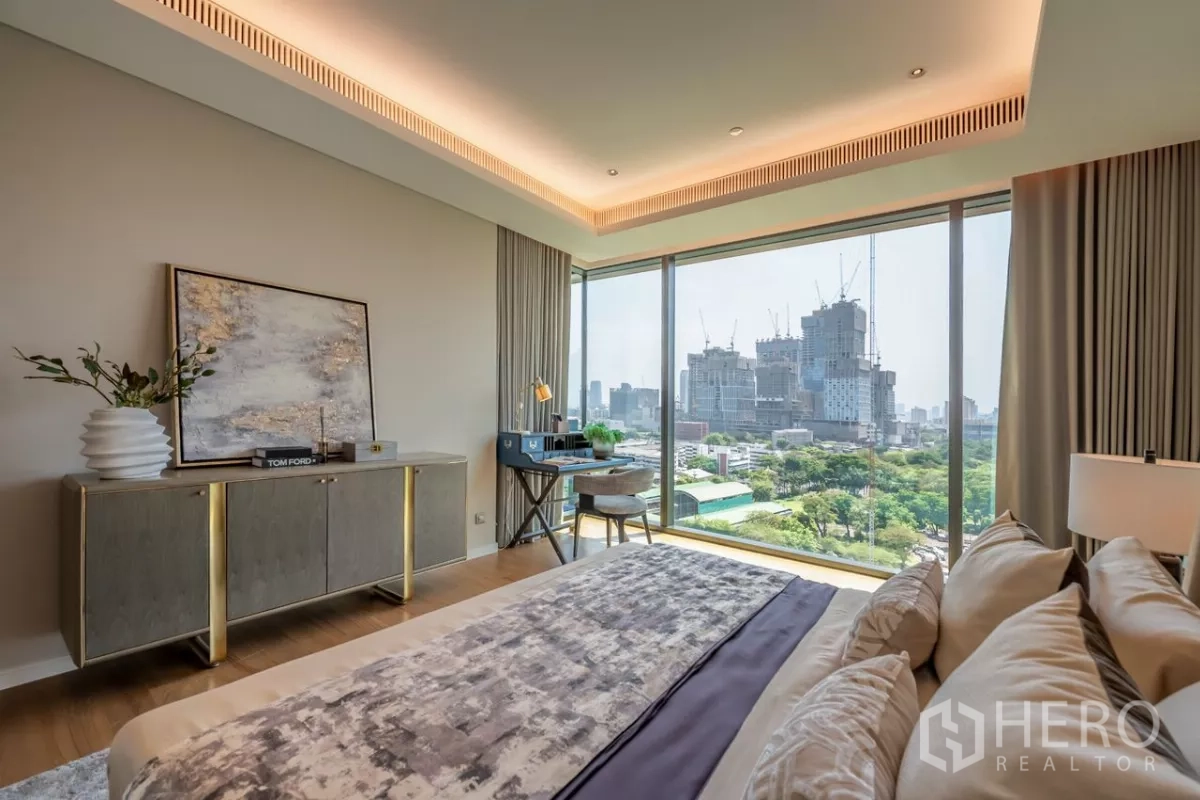 Condominium for rent or sale in Pathum Wan, Bangkok - Bedroom corner with work desk and sweeping green park and cityscape outside.