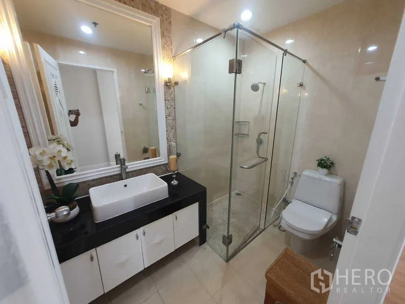 房间 出租在Watthana, Bangkok - 浴室配玻璃淋浴间、洗手台与马桶，米色瓷砖