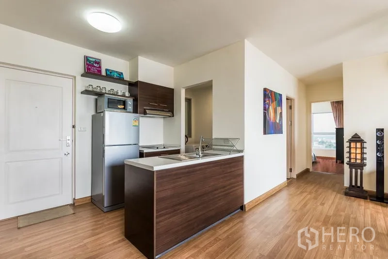 คอนโด ให้เช่าในBang Na, Bangkok - ทางเข้าและครัวแบบเปิด ตู้ลายไม้ เคาน์เตอร์บาร์ และโถงทางเดินสู่ห้องนอน