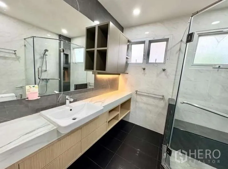 Detached House for rent in Phasi Charoen, Bangkok - Long vanity counter with mirror and under-cabinet lighting beside the shower.