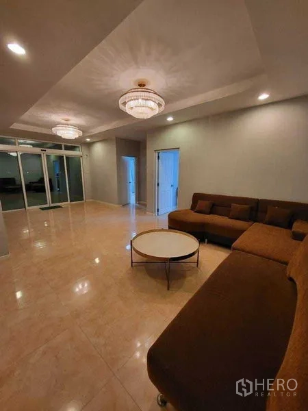 บ้าน ขาย - ห้องนั่งเล่นกว้าง โคมแชนเดอเลียร์ และโซฟาตัวแอล