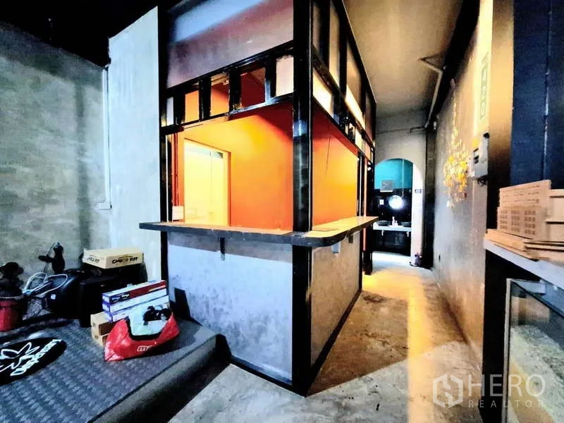 店屋 出租在Bang Rak, Bangkok - 转角服务吧台，橙色内衬与上方置物架。