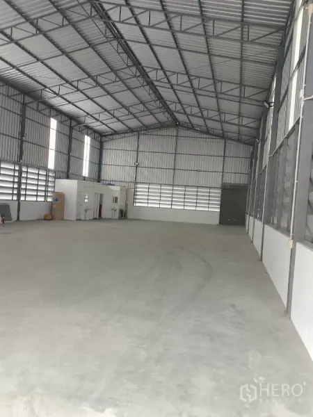 Warehouse for rent in Huai Khwang, Bangkok - Open warehouse floor with about 8 m high steel truss roof and a small office and washrooms.