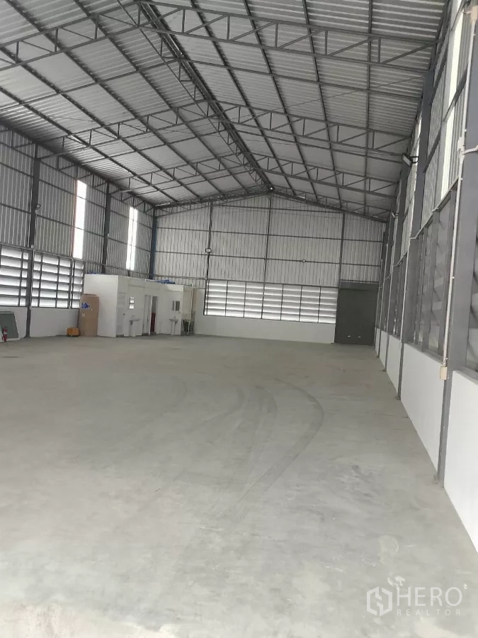 Warehouse for rent in Huai Khwang, Bangkok - Open warehouse floor with about 8 m high steel truss roof and a small office and washrooms.