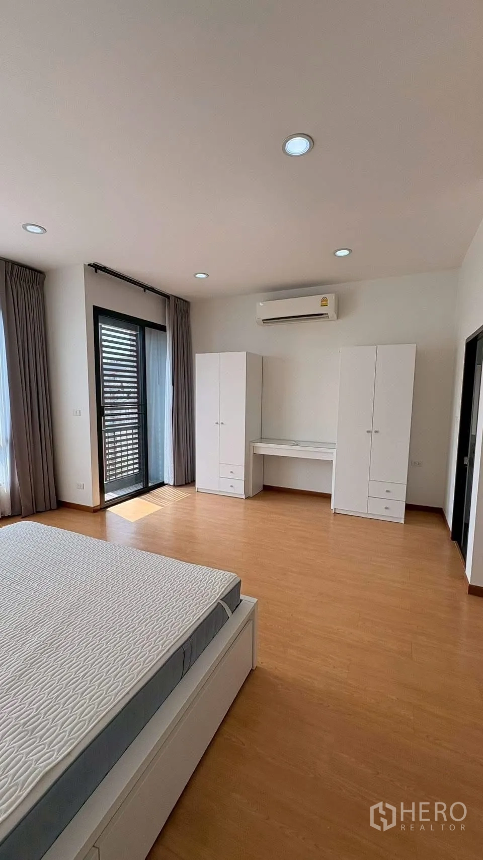 联排别墅 for rent in Phra Khanong, Bangkok - 主卧带阳台门、两组衣柜、书桌和空调。