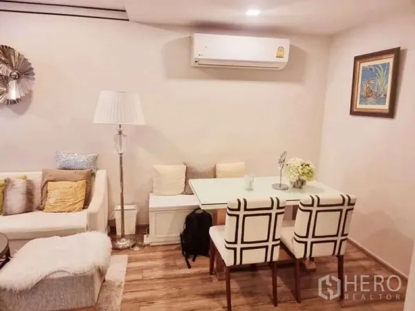 公寓 出售在Bang Rak, Bangkok - 紧凑餐角，靠墙长椅、两把软包椅、落地灯与壁挂空调。