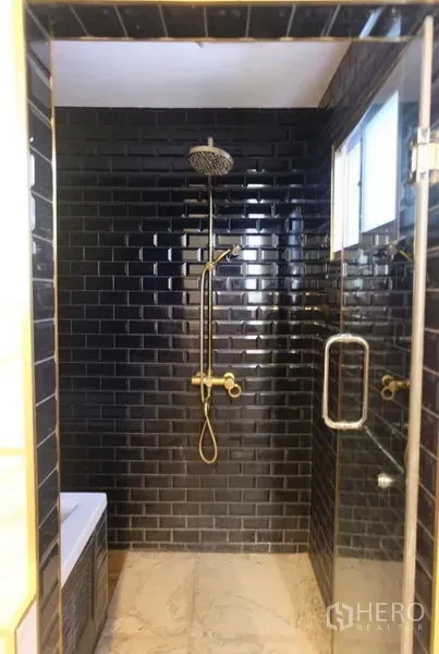 Detached House for rent in Suan Luang, Bangkok - Glass-enclosed shower with black subway tiles, rainfall head, and gold fixtures.