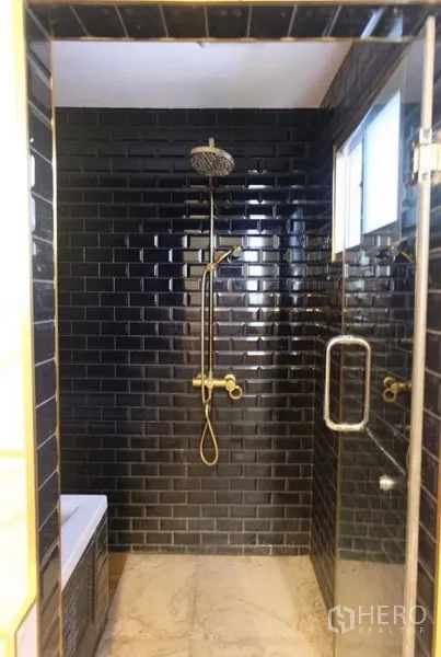 Detached House for rent in Suan Luang, Bangkok - Glass-enclosed shower with black subway tiles, rainfall head, and gold fixtures.
