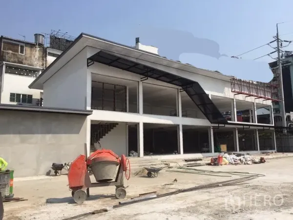 Warehouse for rent in Bang Kapi, Bangkok - Angled view of modern warehouse with stairwell, canopy roof and spacious forecourt for trucks.
