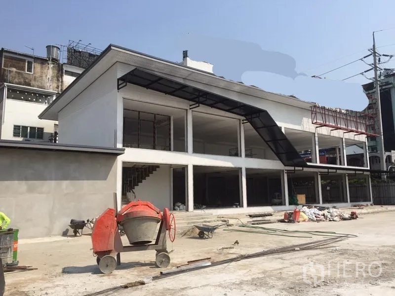 Warehouse for rent in Bang Kapi, Bangkok - Angled view of modern warehouse with stairwell, canopy roof and spacious forecourt for trucks.