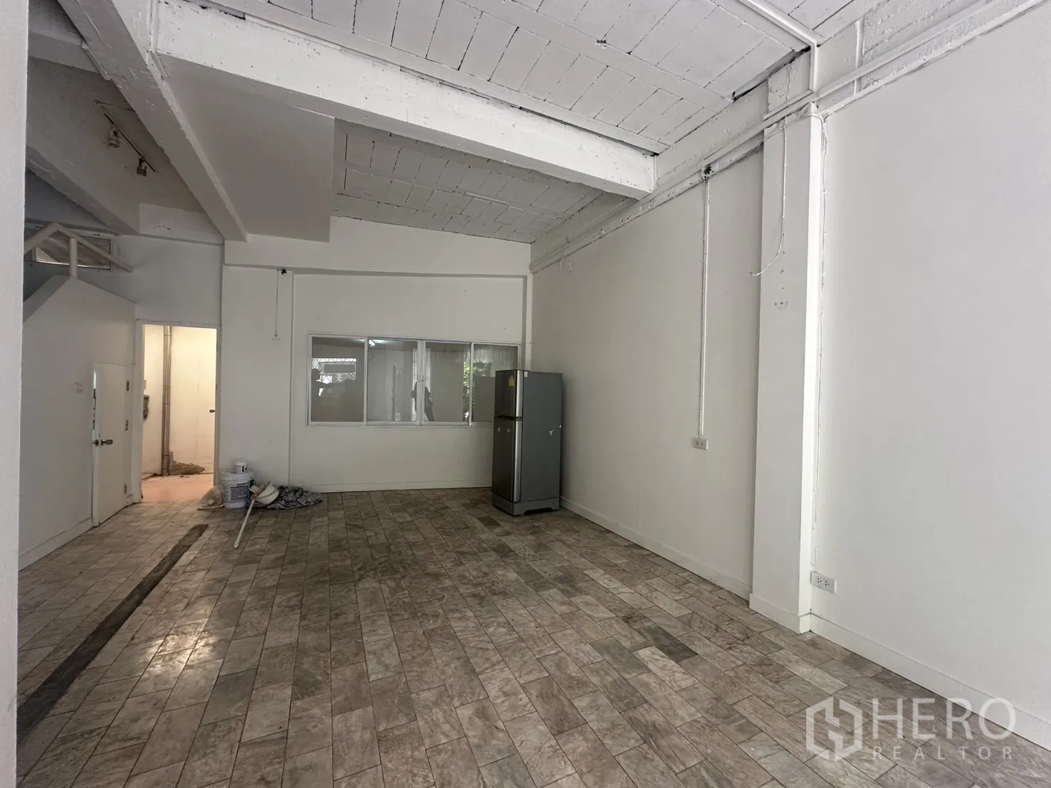 Home Office for rent in Watthana, Bangkok - View of the open-plan room with a windowed partition and a refrigerator.