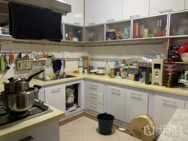 店屋 出售在Pathum Wan, Bangkok - L形内置厨房，白色橱柜、灶台、水槽与抽油烟机。