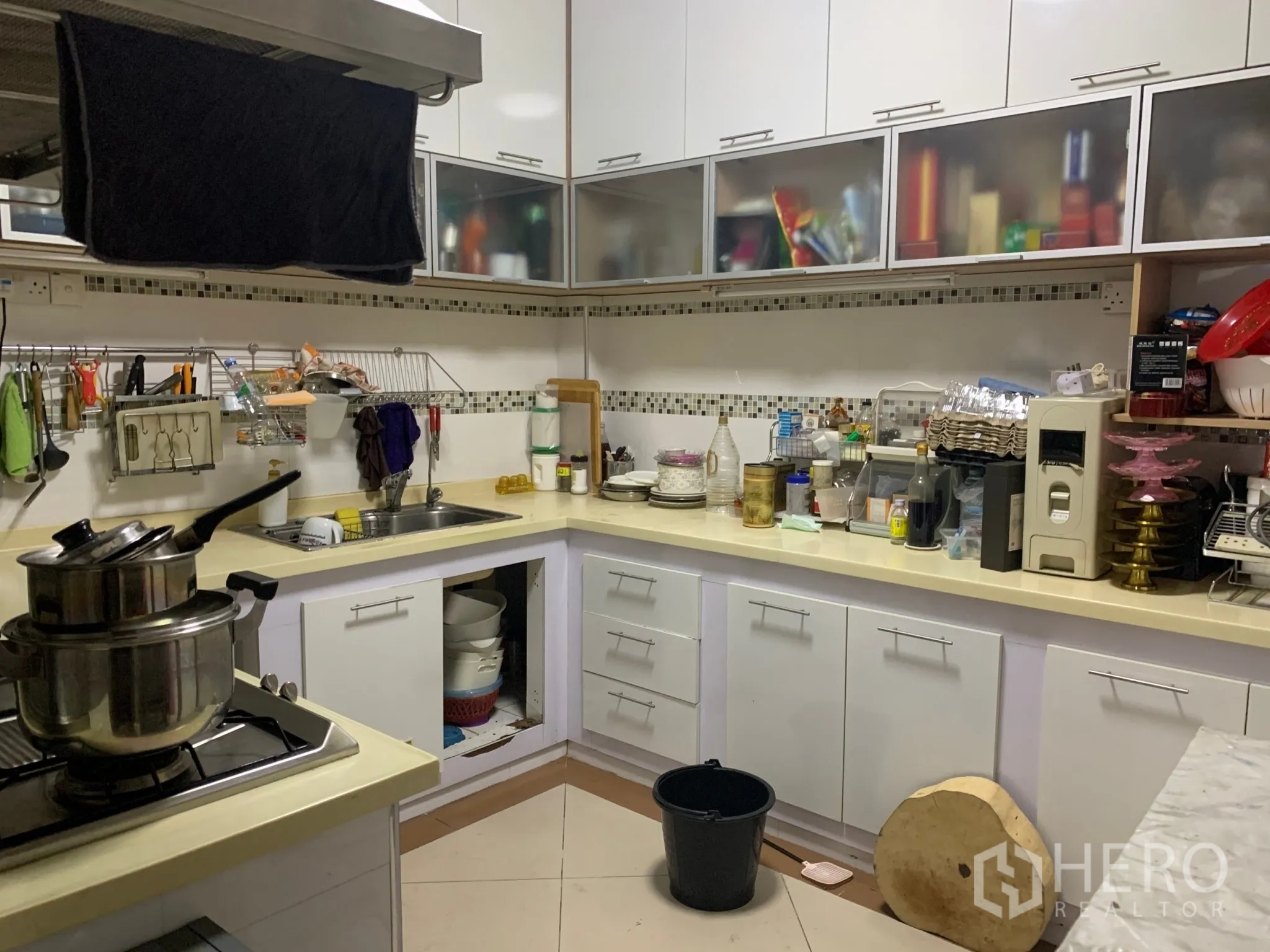 店屋 出售在Pathum Wan, Bangkok - L形内置厨房，白色橱柜、灶台、水槽与抽油烟机。