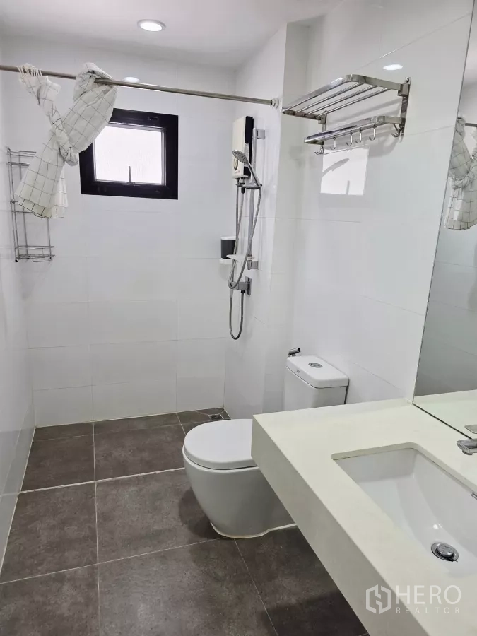 Detached House for rent in Prawet, Bangkok - Bathroom with walk-in shower, handheld spray, vanity counter and toilet.