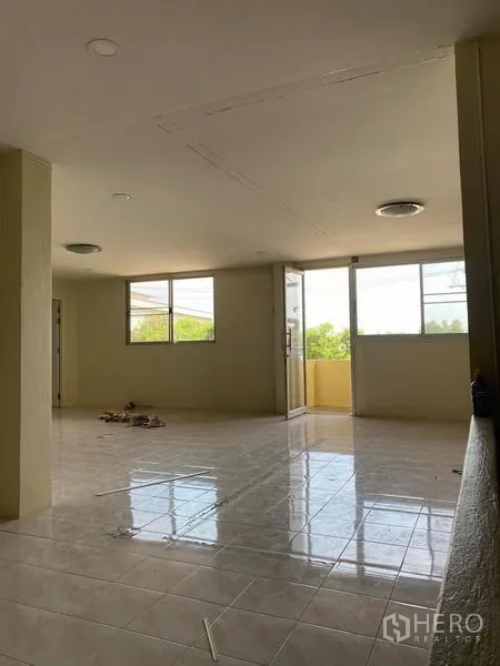 工厂 出租在Samut Sakhon - 采光良好的瓷砖房间，设大窗与通向小阳台的门，适合作为办公室或员工区。