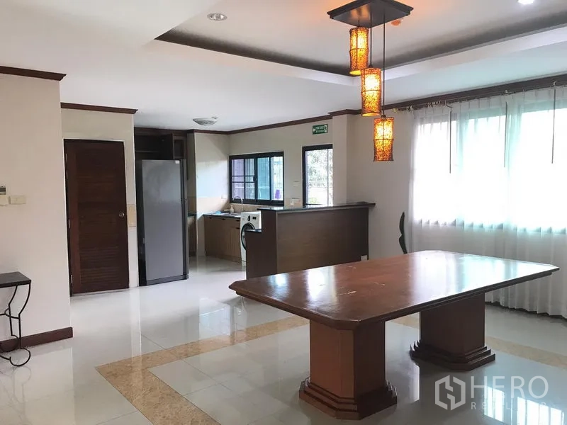 อพาร์ทเมนท์ ให้เช่าในWatthana, Bangkok - พื้นที่รับประทานอาหารแบบเปิดพร้อมโต๊ะไม้ โคมไฟแขวน และครัวกึ่งเปิดข้างหน้าต่างบานใหญ่