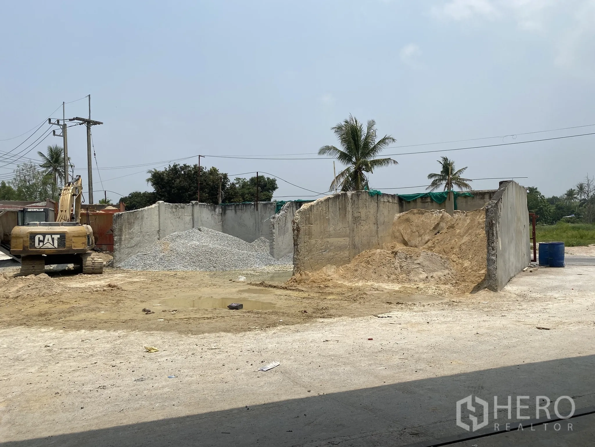 Factory for sale in Mueang Chon Buri, Chon Buri - Open yard with sand and gravel storage bays and an excavator.