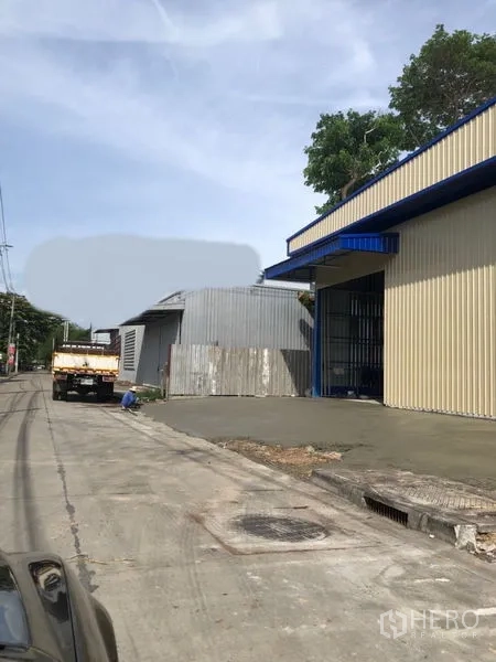 คลังสินค้า ให้เช่าในBang Kapi, Bangkok - ภายนอกโกดังผนังเมทัลชีท มีประตูม้วนกว้าง ติดถนนในย่านบางกะปิ