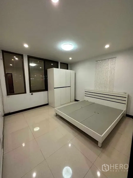 อาคารพาณิชย์ ให้เช่าในChatuchak, Bangkok - ห้องนอนกว้าง เตียงและตู้เสื้อผ้าสีขาวริมหน้าต่างบานใหญ่.