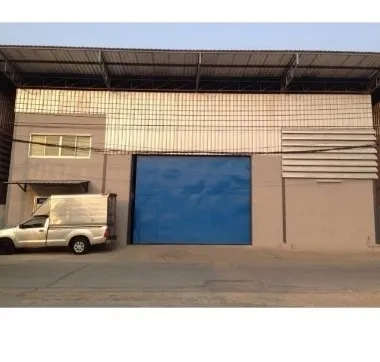 คลังสินค้า ให้เช่าในBang Kapi, Bangkok - ด้านหน้าโกดังย่านบางกะปิ ประตูโหลดสินค้าสีฟ้าบานใหญ่ หลังคาเมทัลชีท ติดถนนเข้าออกง่าย