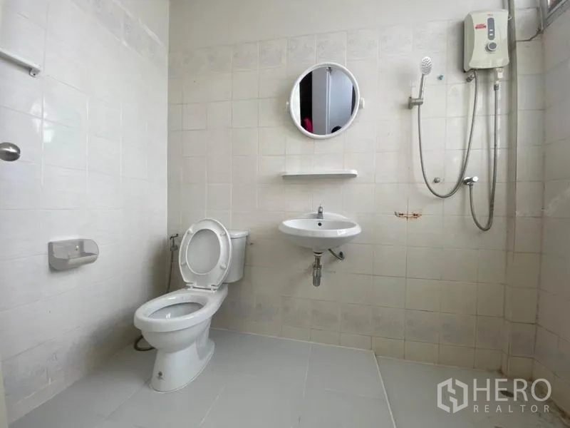 ทาวน์เฮาส์ ให้เช่าในWatthana, Bangkok - ห้องน้ำปูกระเบื้องสีขาวพร้อมฝักบัว เครื่องทำน้ำอุ่น กระจกทรงกลม และชักโครก.