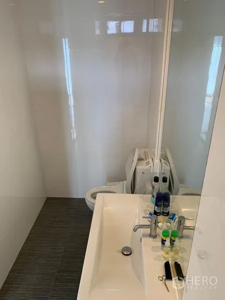 Office Space for sale in Saphan Sung, Bangkok - Modern bathroom with wide vanity, large mirror and white tiled walls.