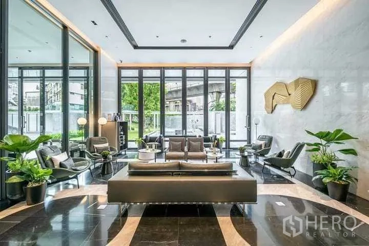 公寓 出租或出售在Khlong Toei, Bangkok - 公寓大堂，休闲座椅、亮面大理石地面与花园景观。
