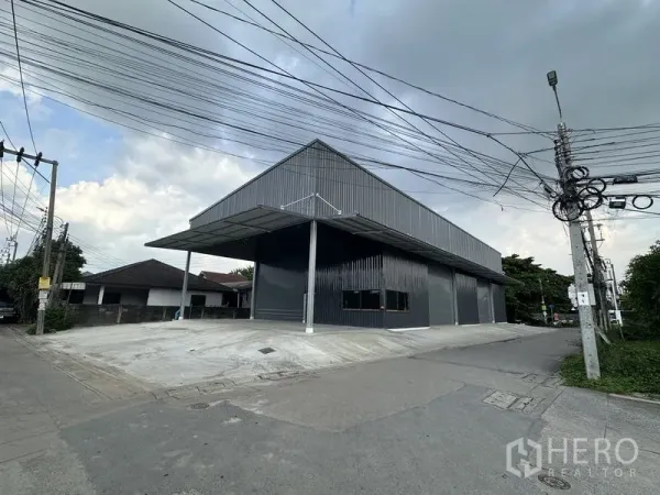 คลังสินค้า ให้เช่าในBang Kapi, Bangkok - มุมมองริมถนนของโกดังสีเข้ม พร้อมท่าโหลดมีหลังคาและที่จอดรถกลางแจ้ง