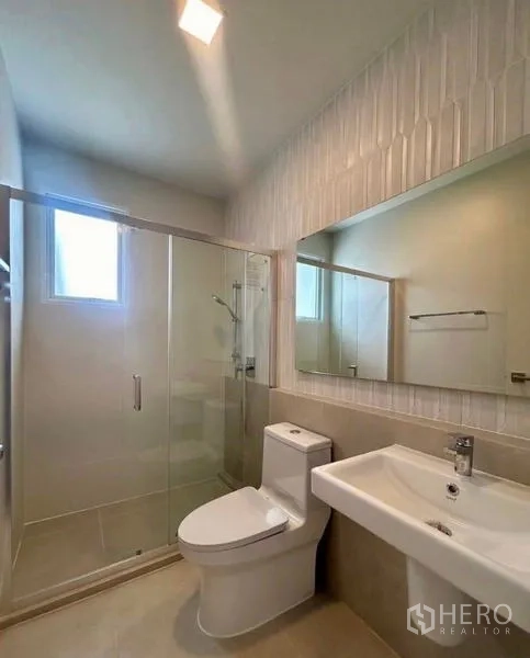 Townhouse for rent in Bang Phli, Samut Prakan - Contemporary bathroom with glass-enclosed shower, toilet and vanity.