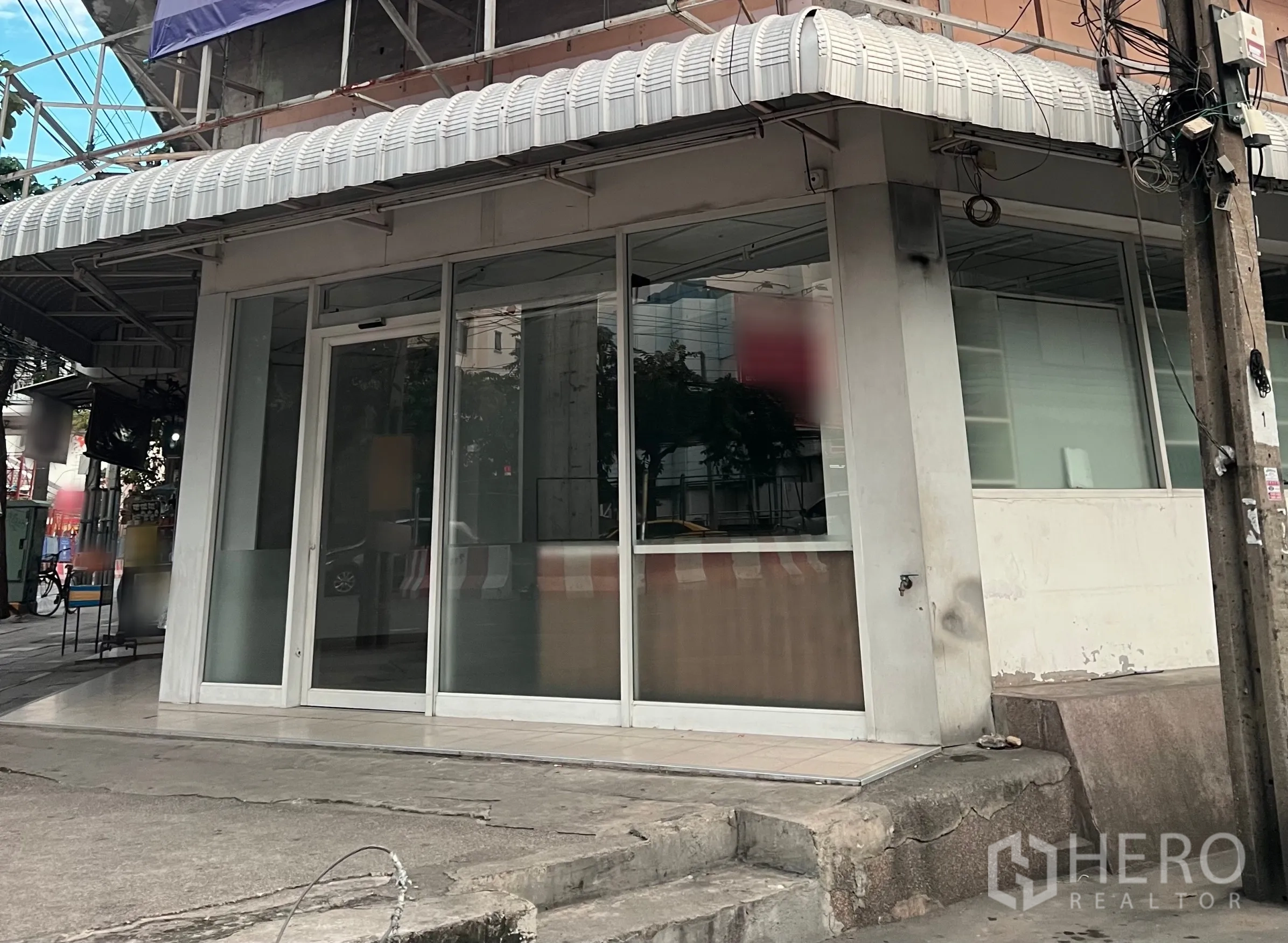 零售空间 出租在Chatuchak, Bangkok - 曼谷乍都节转角店面，整面玻璃立面与滑动门，配有雨棚与人行道入口。