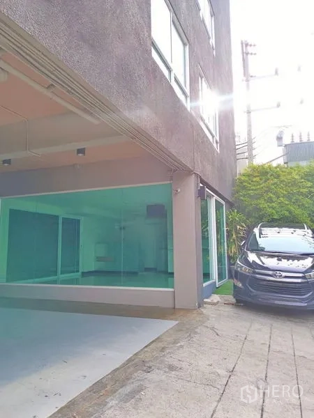 พื้นที่ขายปลีก ให้เช่า - มุมอาคารเตี้ยแสดงหน้าร้านกระจกและที่จอดรถหน้าร้าน