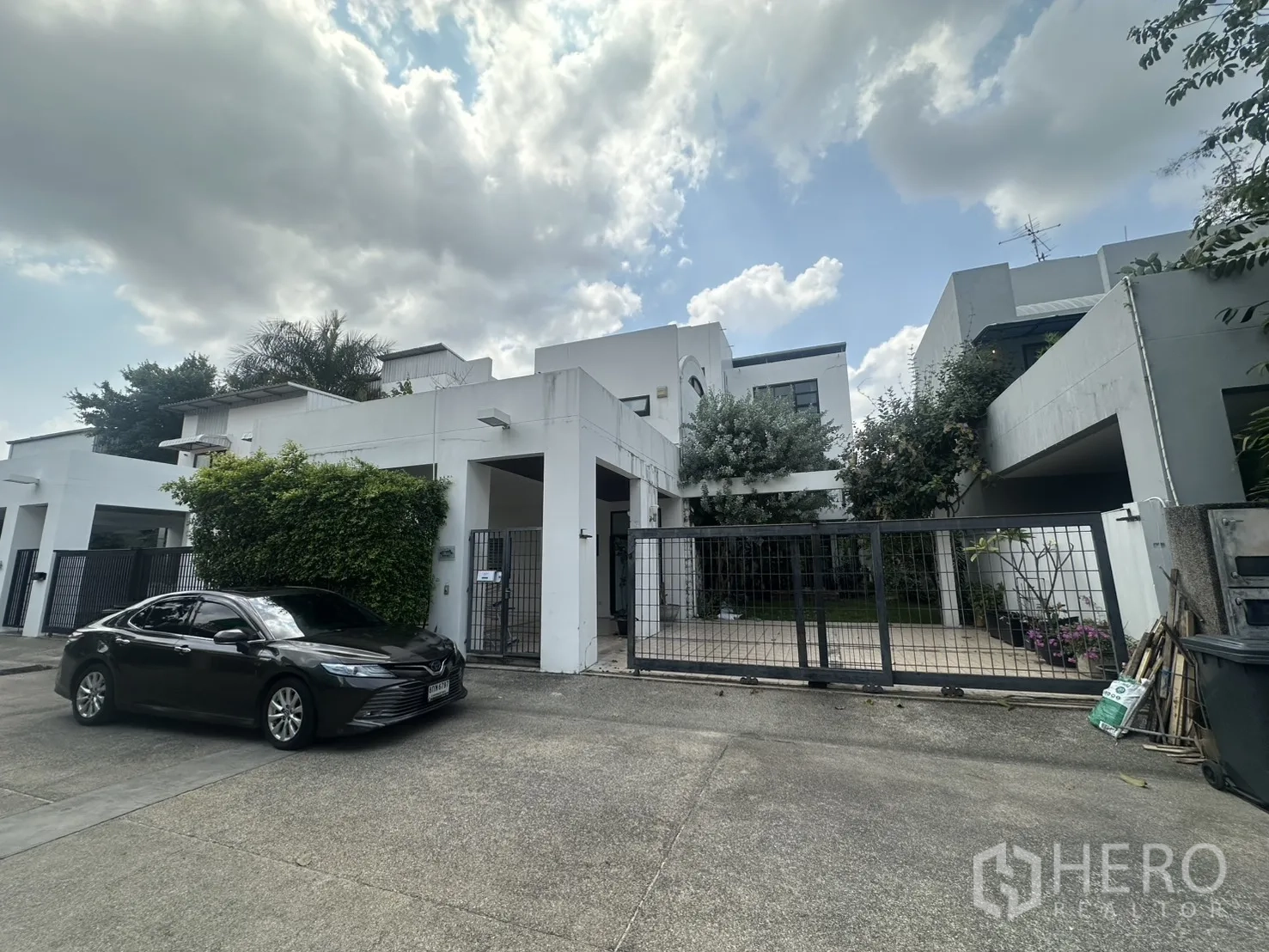 独栋房屋 for rent in Watthana, Bangkok - 现代白色独栋外观，带围栏与车道