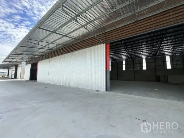 货栈 出租在Lam Luk Ka, Pathum Thani - 一排现代仓库，开放式装卸湾、金属墙面与带顶棚的卡车装卸区。