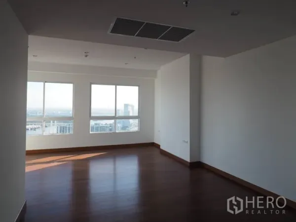 Condominium for rent or sale in Yan Nawa, Bangkok - Corner bedroom with wooden flooring and wide city views.